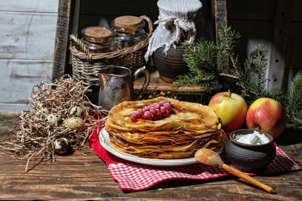 Adobe Stock - Photo d'illustration - Une assiette de crêpes servie avec des pommes, des groseilles et de la crème fraîche.