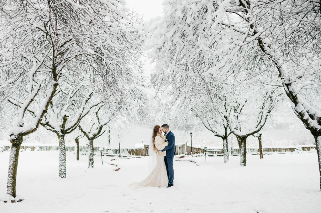 Adobe Stock - Photo d'illustration - Couple de mariés qui prend des photos de son mariage sous un joli paysage enneigé.