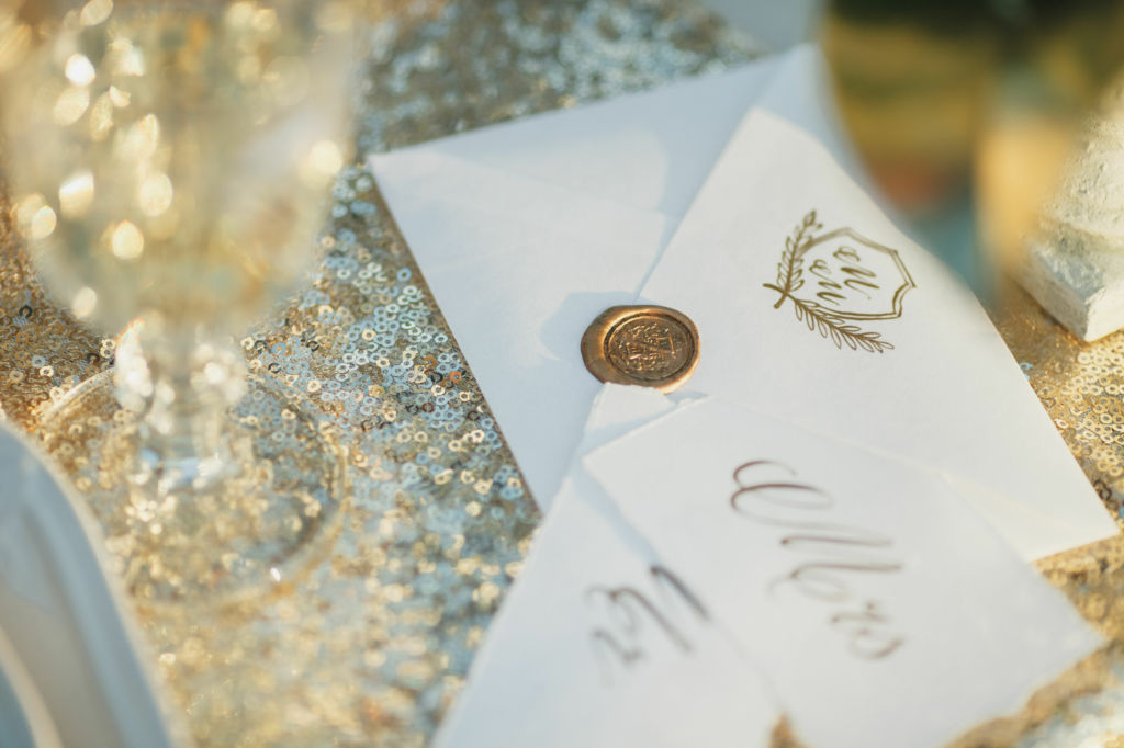 Adobe Stock - Photo d'illustration - Des lettres d'invitation scellées à la cire de bougie dorée.