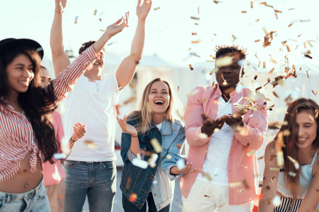 Adobe Stock - Photo d'illustration - Heureux, un groupe d'amis fait la fête et lance des confettis.