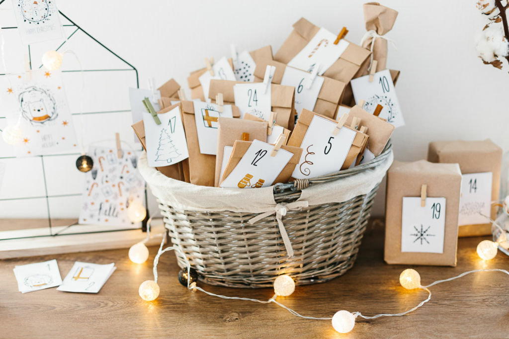 Adobe Stock - Photo d'illustration - Panier en osier rempli de petites pochettes surprise en carton personnalisées.