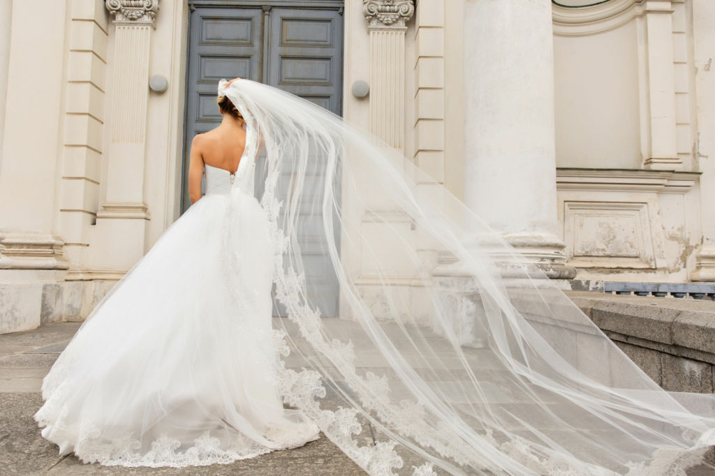 Adobe Stock - Photo d'illustration - Laisser son voile de mariée suivre le courant du vent pour ses photos de mariage.
