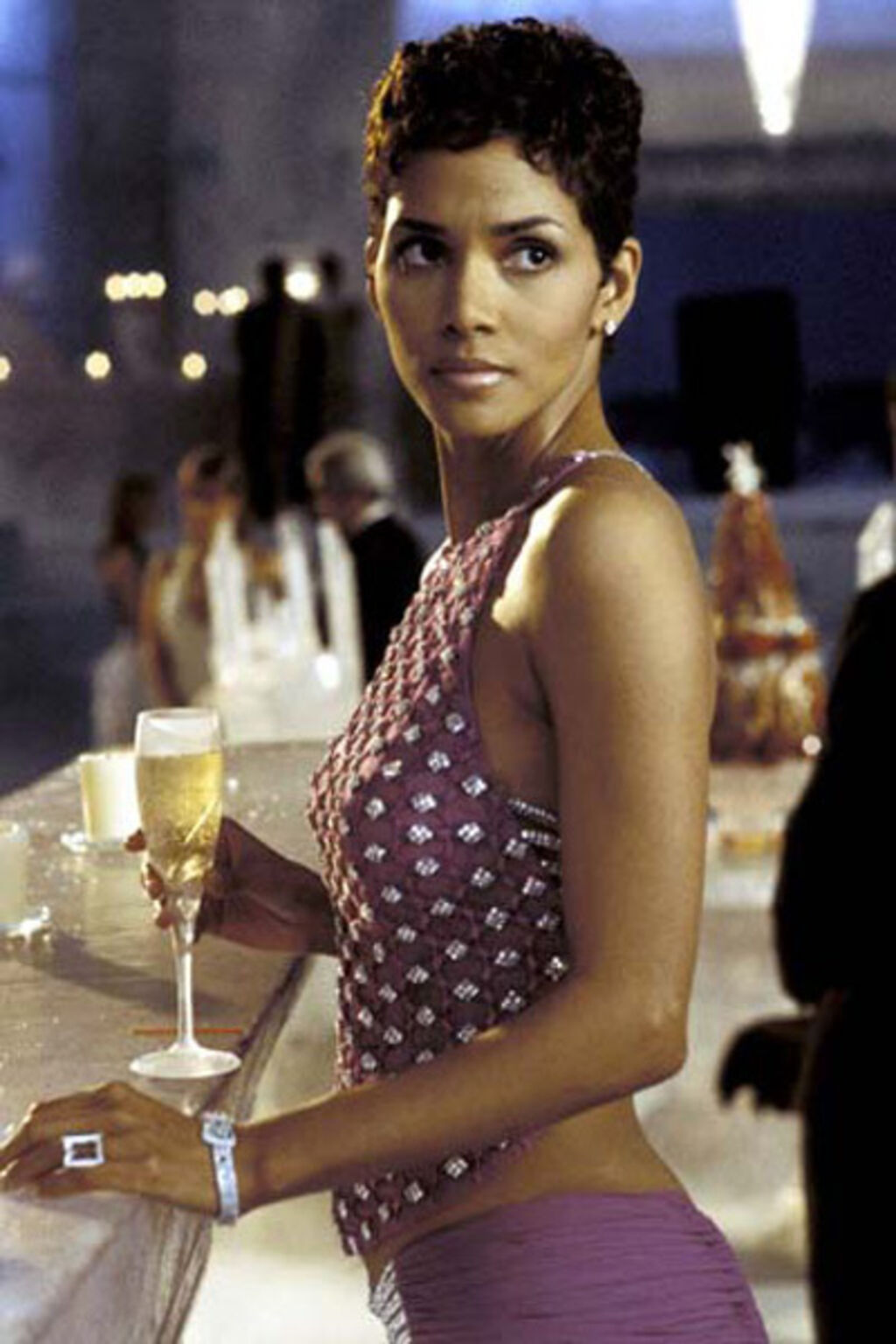 Allociné - Jinx, avec un haut violet à strass, interprétée par Halle Berry.