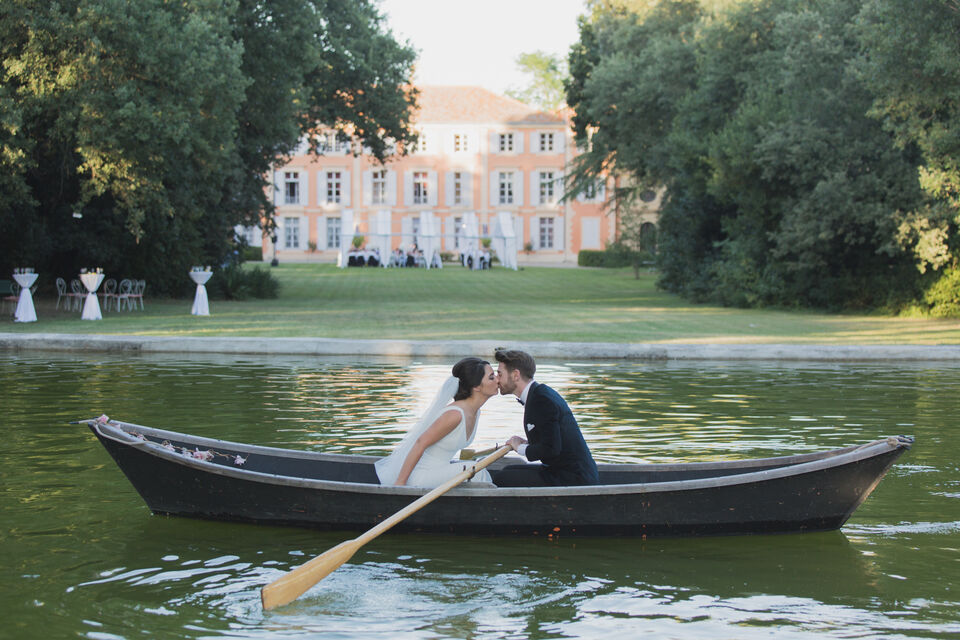 ABC Salles - Ce couple de mariés partage un moment romantique sur une barque, longeant le bassin qui entoure le château de Roquelune.