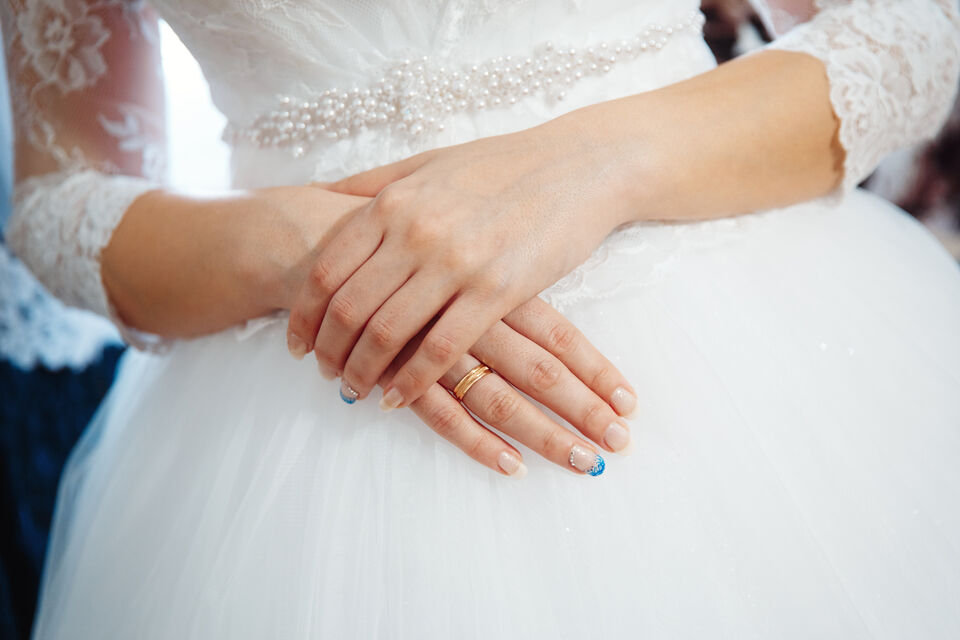 Adobe Stock - photo d'illustration - Cette mariée arbore une french manucure, avec une touche de couleur et de strass, pour une note d'originalité.