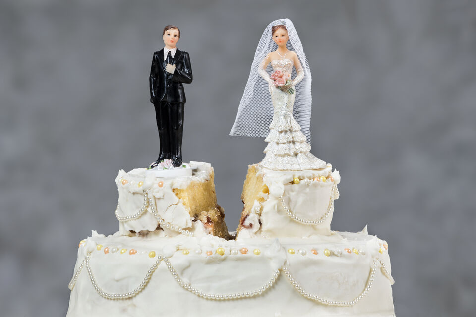 Adobe Stock - Un gâteau de mariage coupé en deux. Du côté droit la mariée, du côté gauche le marié. Il symbolise le divorce, la séparation.<br>