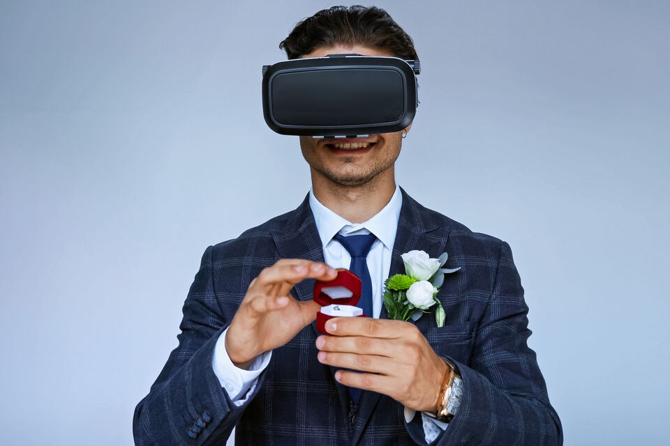 Adobe Stock - photo d'illustration - Équipé d'un casque à réalité virtuelle, un homme, habillé en costume ,semble effectuer sa demande en mariage dans un monde digital à l'instar du Métavers.<br>