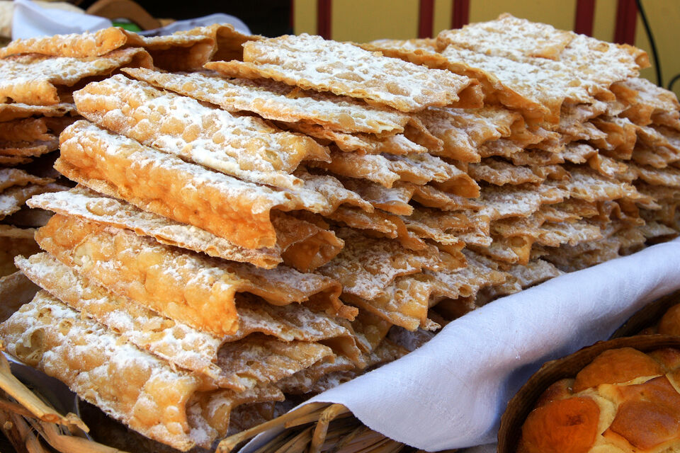 Adobe Stock - Oreillettes, ces beignets à pâte fine saupoudrés de sucre glace.