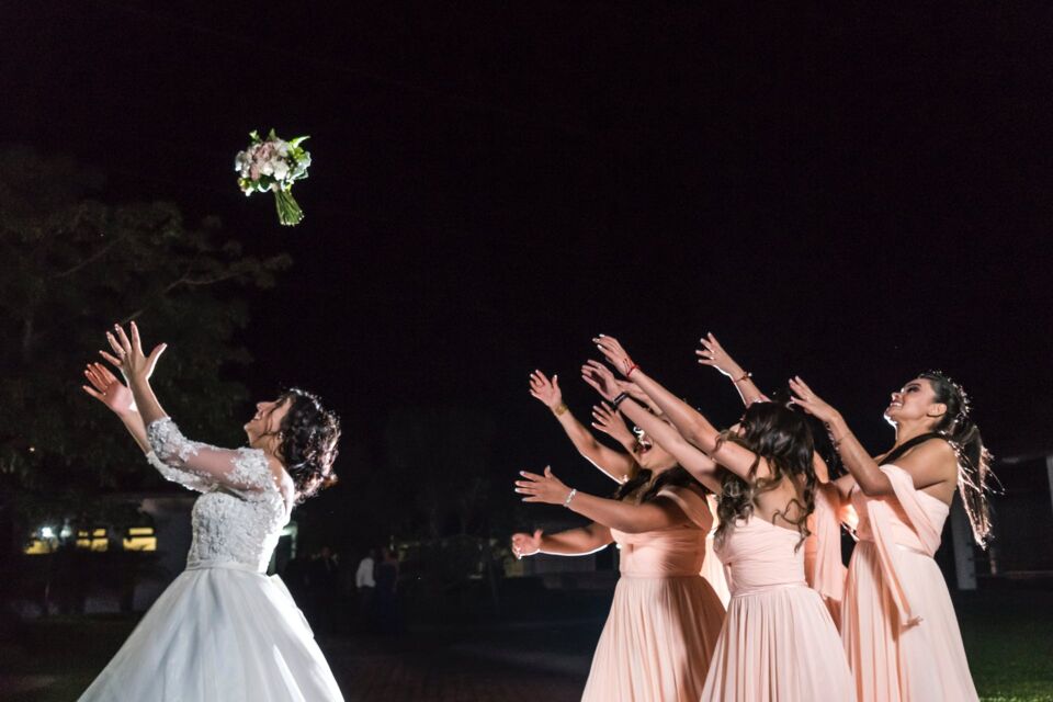 Pexels - Photo d'illustration - Ciel étoilé et vœux de bonheur : une mariée lance son bouquet dans la nuit, promettant chance et amour à celle qui l'attrapera.