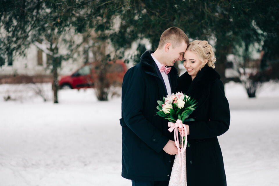 Freepik - Photo d’illustration - Couple de jeunes mariés heureux s'étreint sous la neige étincelante, ce partageant des rires complices et des promesses éternelles.