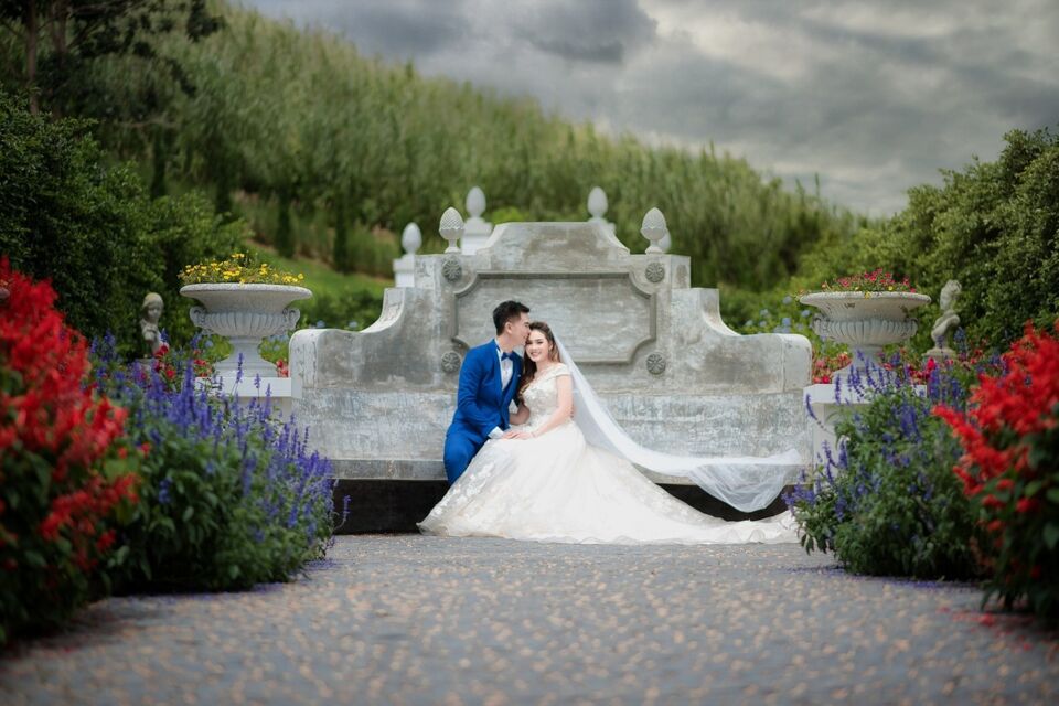 Pexels - Photo d'illustration - Un couple de jeunes mariés, entourés de splendides décorations extérieures, célèbre leur amour au milieu d'un éclatant jardin de fleurs multicolores, symbolisant la joie et la diversité de leur union.