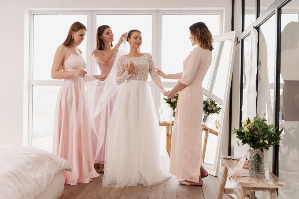 Freepik - Photo d'illustration - Une mariée rayonnante de sérénité se prépare pour son grand jour, entourée de ses demoiselles d'honneur dévouées. Son sourire paisible et son regard empli de bonheur témoignent de la joie et de l'excitation qui précèdent les moments magiques à venir.