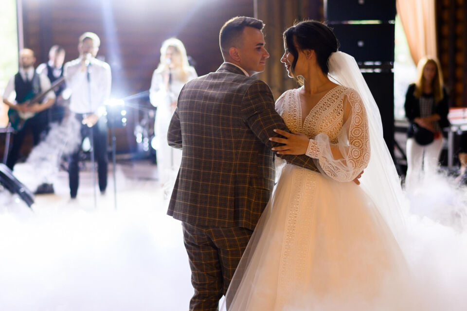 Freepik - Photo d'illustration - Couple de mariés partageant un moment magique, dansant au son d'une chanson interprétée par un groupe de musique live, une animation envoûtante de leur mariage.