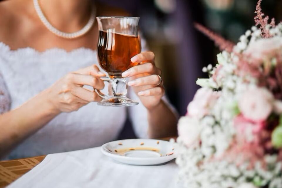 Freepik - Photo d’illustration - Dans l'atmosphère enchanteresse de son bar à thé de mariage, la mariée savoure délicatement une tasse, rayonnante dans sa robe blanche.