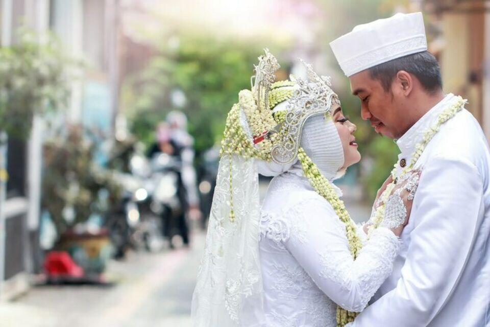 Freepik - Photo d'illustration - Jeune couple de mariés habillés en tenue traditionnelle de mariage, célèbre son union en Malaisie.