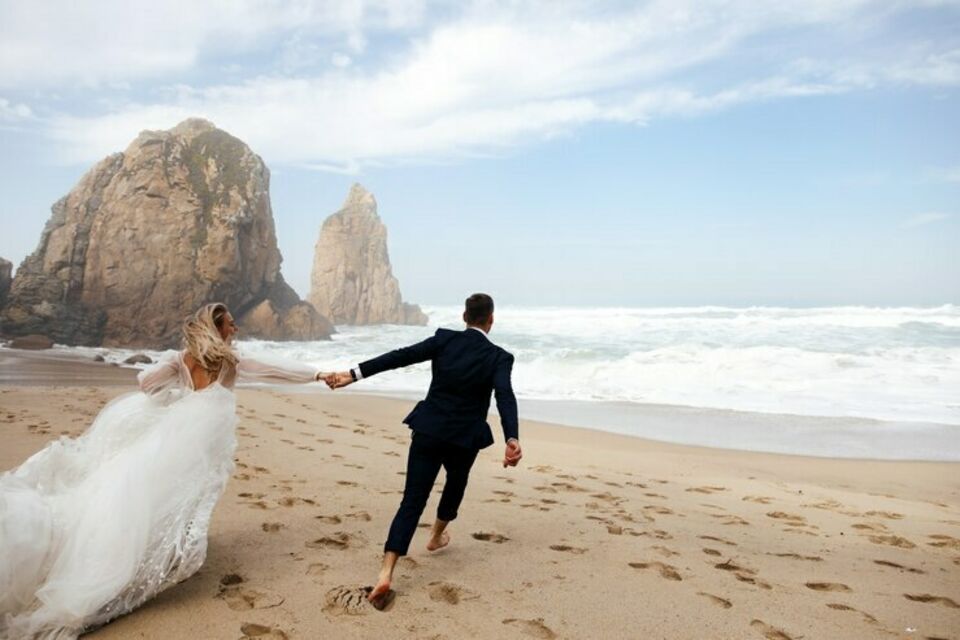 Freepik - Photo d'illustration - Un couple de jeunes mariés savourent quelques instant sur une magnifique plage australienne. Le mariage en Australie est souvent célébré entouré d'éléments de la nature.