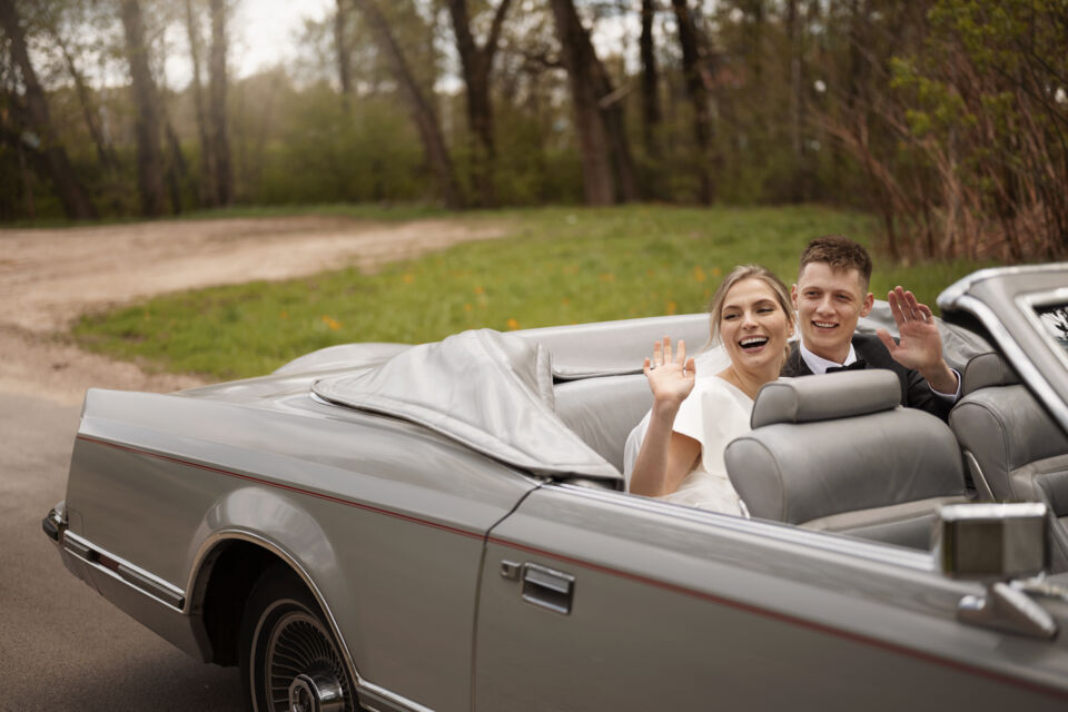 Freepik - Photo d'illustration -  Un couple de jeunes mariés dans voiture décapotable modèle d'époque reflétant parfaitement le thème du mariage vintage et rétro.