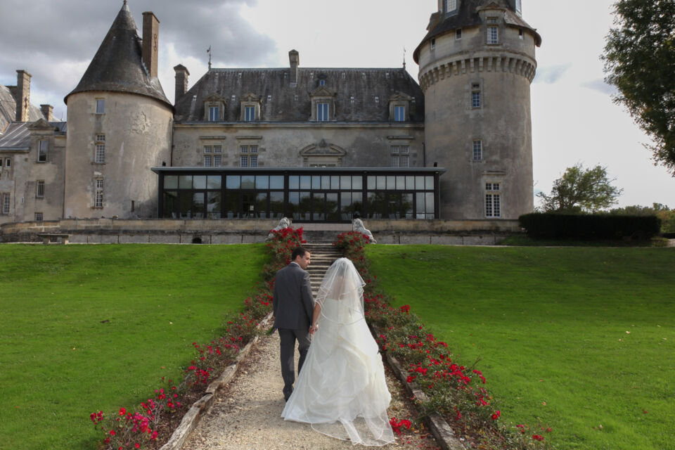 Adobe Stock - Photo d'illustration - Jeune couple de mariés se dirigeant vers un magnifique château datant de l'époque médiévale. Les jeunes époux s'apprêtent à célébrer leur union dans une atmosphère imprégnée du Moyen-Age. 