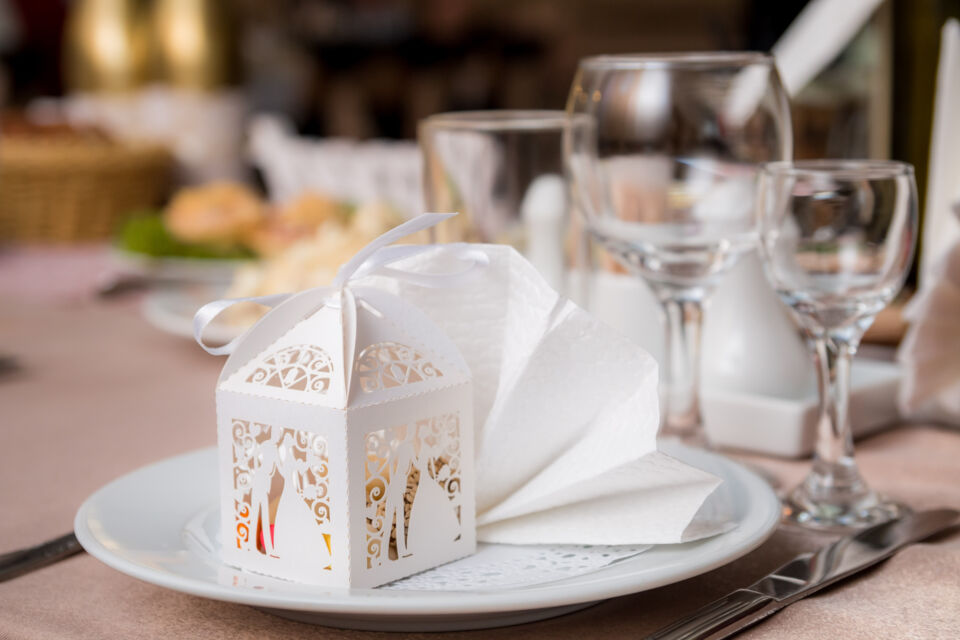 Adobe Stock - Photo d'illustration - De délicates faveurs de mariage, élégamment emballées et disposées sur une assiette, apportent une touche de raffinement à la table.