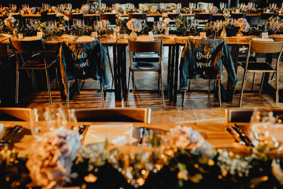 Adobe Stock - Photo d'illustration - Des tables élégamment décorées dans un style chic industriel, mêlant bois brut, métal et touches végétales pour une ambiance moderne et raffinée.