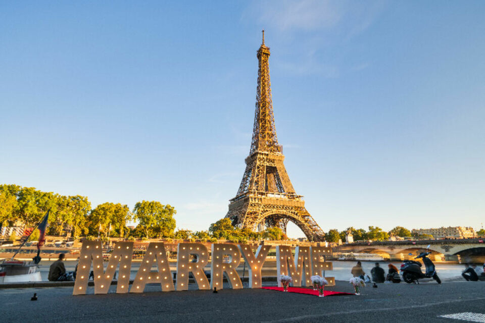 Adobe Stock - Photo d'illustration -&nbsp;Des lettres lumineuses au pied de la Tour Eiffel créent une atmosphère magique et romantique, sublimant ce lieu emblématique pour une déclaration d'amour inoubliable.