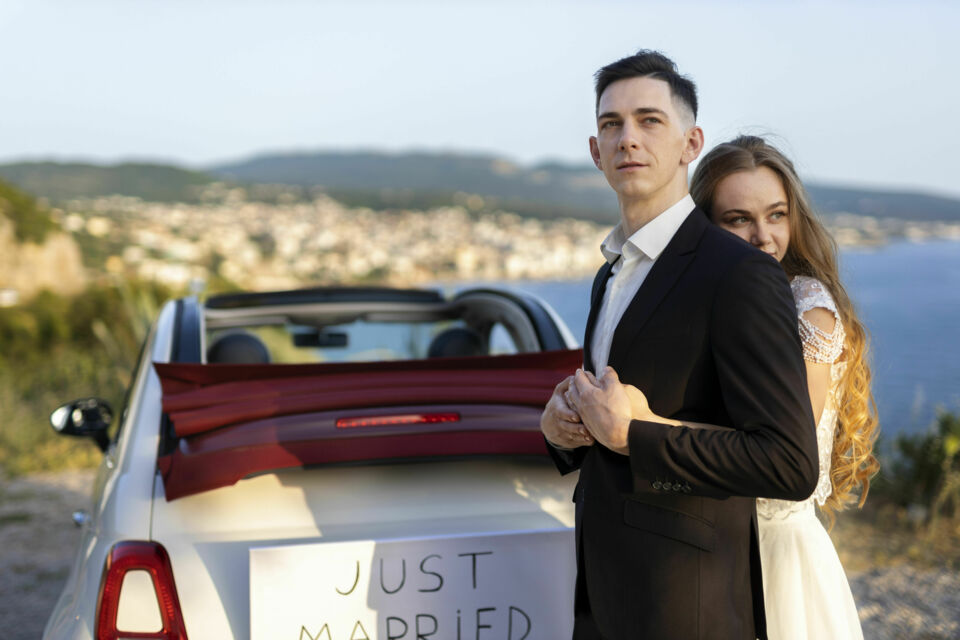 Freepik - Photo d'illustration - Jeune couple de marié s'apprêtant à partir en road trip, une alternative au voyage de noces traditionnel. 