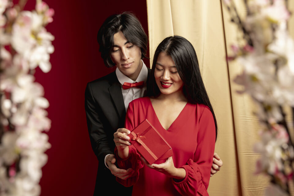 Freepik - Photo d'illustration - Un moment empreint de joie : les jeunes mariés découvrent un cadeau chargé de symbolisme et de bons vœux, reflet des traditions et de l’amour partagé.