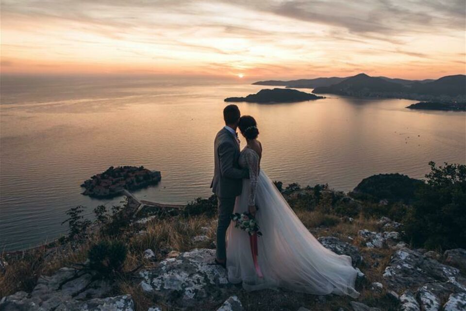 Adobe Stock - Photo d'illustration - Un couple en tenue nuptiale, main dans la main, contemple la mer le jour J. Un moment de sérénité, empreint d'émotion, où l'horizon infini symbolise l'avenir et les promesses d'une vie à deux. Un instant suspendu, loin de l'agitation de la journée, capturant la beauté et l'intimité du mariage.