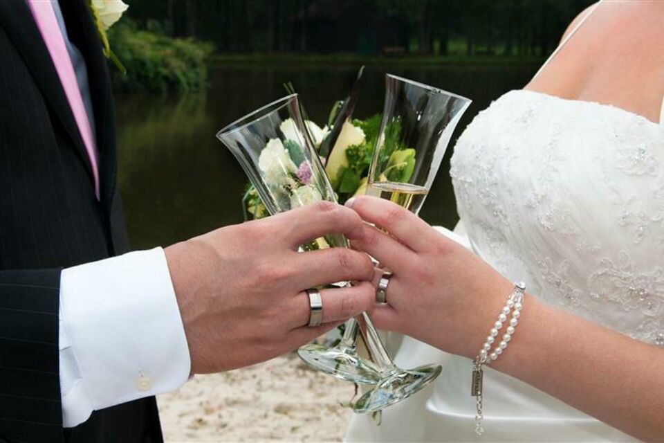 Adobe Stock - Photo d'illustration - Entrecroiser les mains pour boire du champagne le jour de son mariage fait partie de ces traditions peines de sens que l'on honore avec amour.