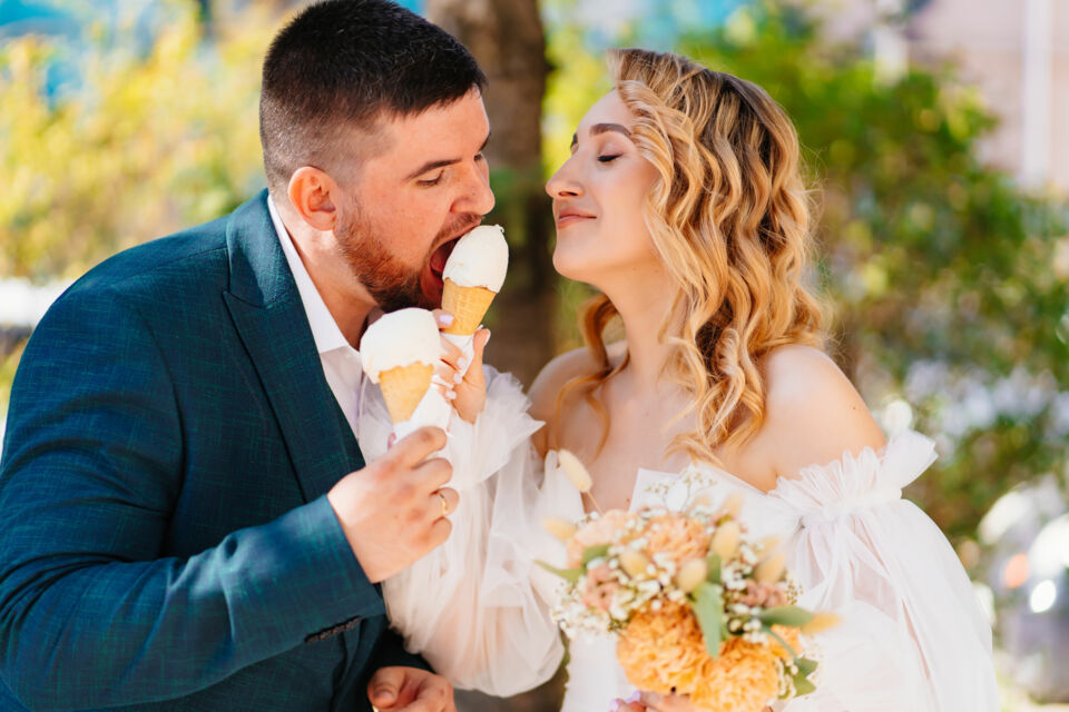 Adobe Stock - Photo d'illustration - Un moment de complicité et de douceur : les nouveaux mariés savourent leur bonheur, un cornet de glace à la main, après une journée mémorable.