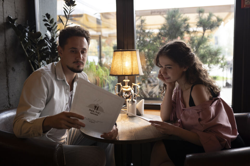 Freepik - Photo d'illustration - À la lumière douce d’un café, deux amoureux feuillettent le menu comme on feuillette l’avenir : complicité, projets et conversations essentielles avant de dire oui pour la vie.