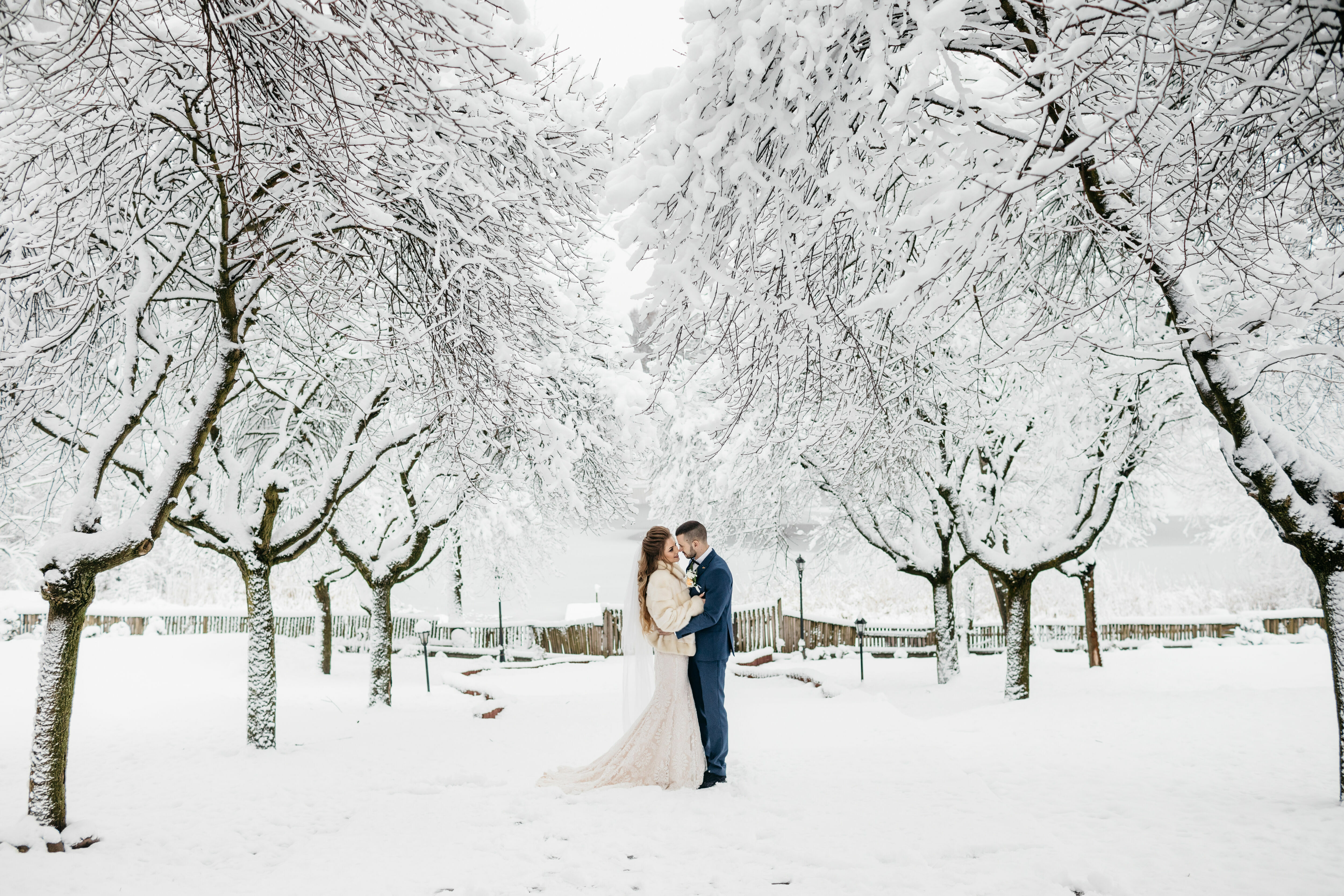 Adobe Stock - Photo d'illustration - Couple de mariés qui prend des photos de son mariage sous un joli paysage enneigé.