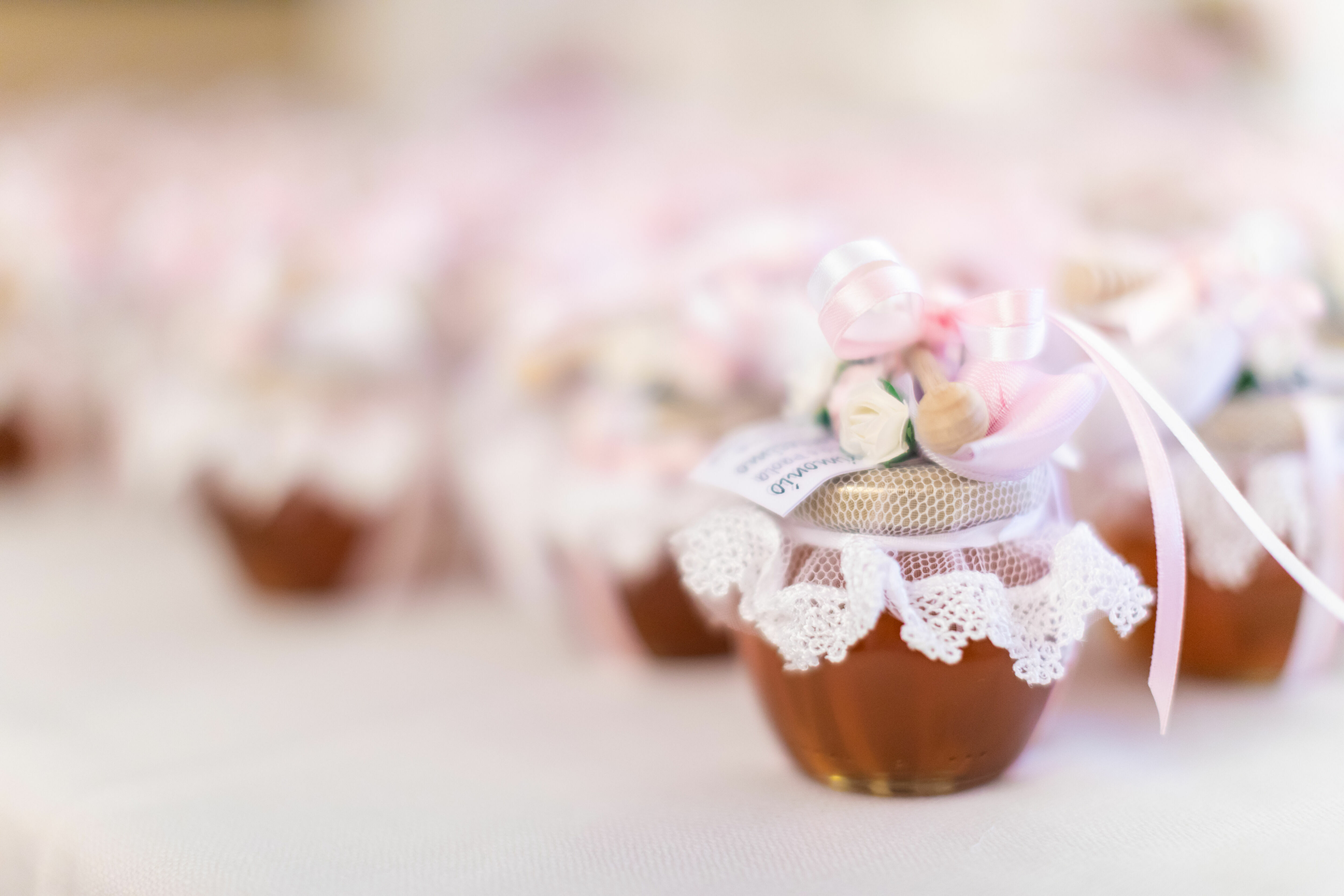 Adobe Stock - Photo d'illustration - Des pots de miel scellés par un ruban en guise de cadeaux pour les invités.