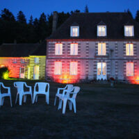 Façade du manoir éclairée en soirée