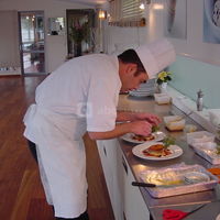 Le chef concocte un repas devant le client