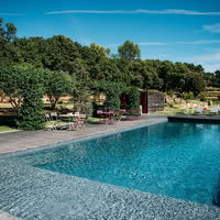 La piscine chauffée du Mas de So au pied des vignes et la cuisine d'été sous la pergola de jasmins