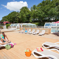Une grande terrasse en bois en bor de piscine