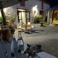 Terrasse et véranda éclairée le soir, donnant sur l'accueil