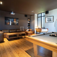 Grand salon home cinema avec un billard et un écran de projection géant