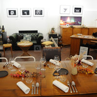 Table dressée et espace salon au fond pour un repas gastronomique dans la galerie