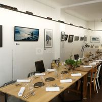 Tables dressées et espace de travail au fond pour un repas gastronomique dans la galerie