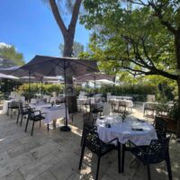 Une belle et grande terrasse d'été avec sa cuisine d'été et sa vue piscine