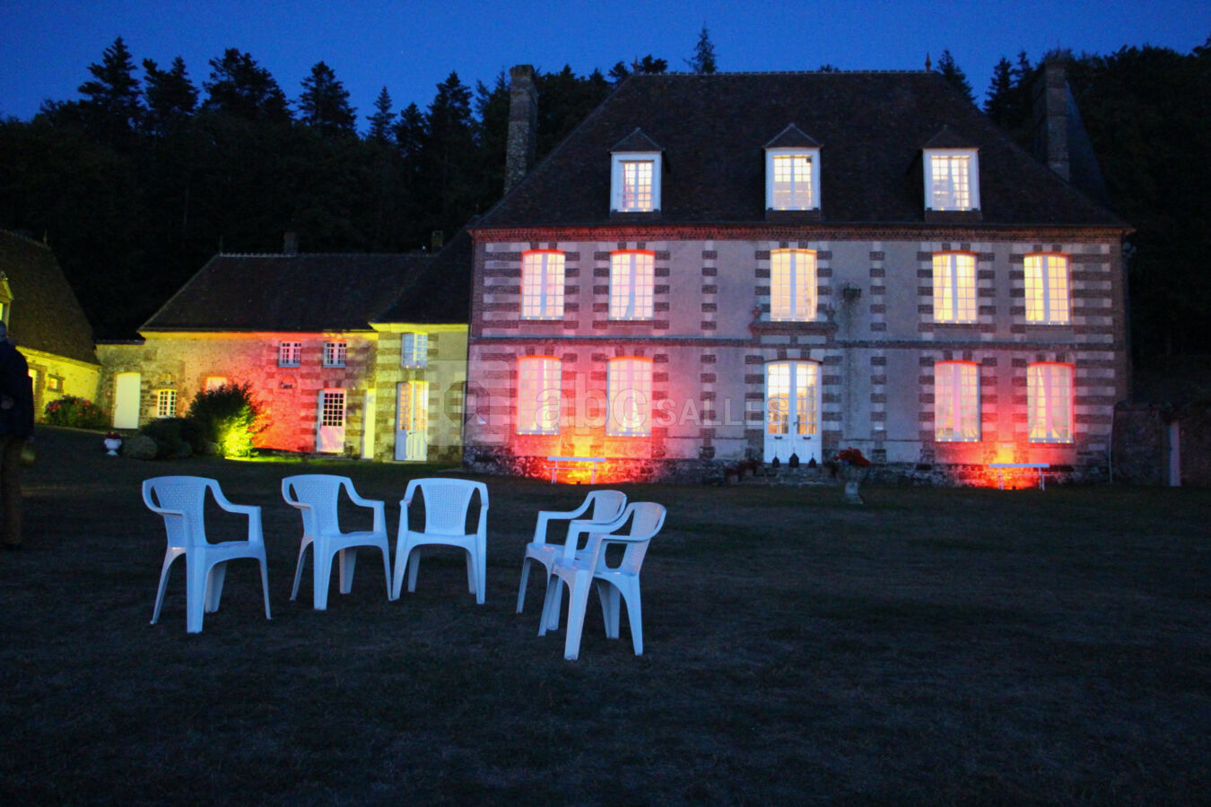 Façade du manoir éclairée en soirée