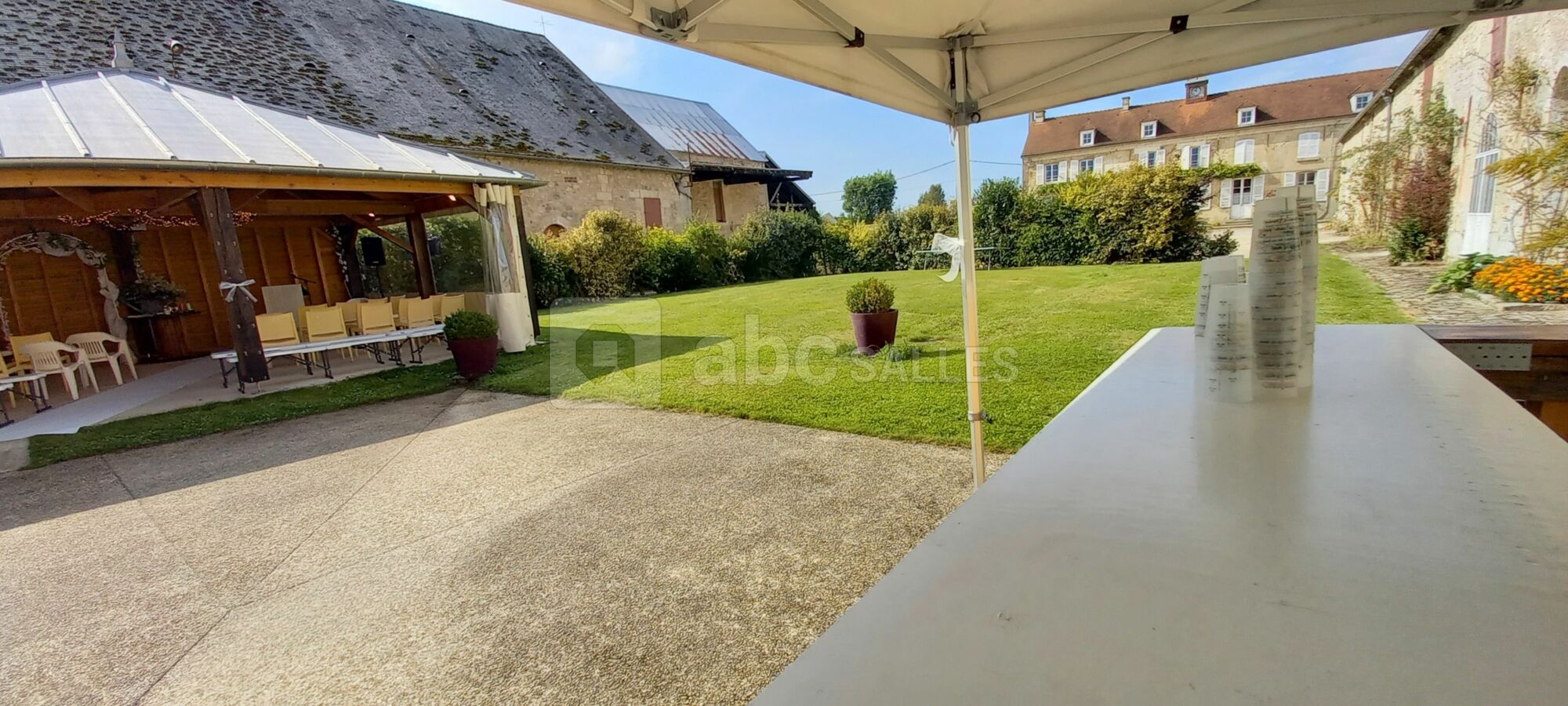 Chaises installées en véranda, cocktail au bar en terrasse donnant sur le jardin clos