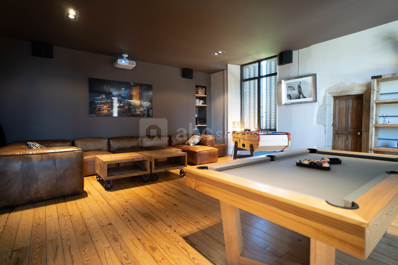 Grand salon home cinema avec un billard et un écran de projection géant