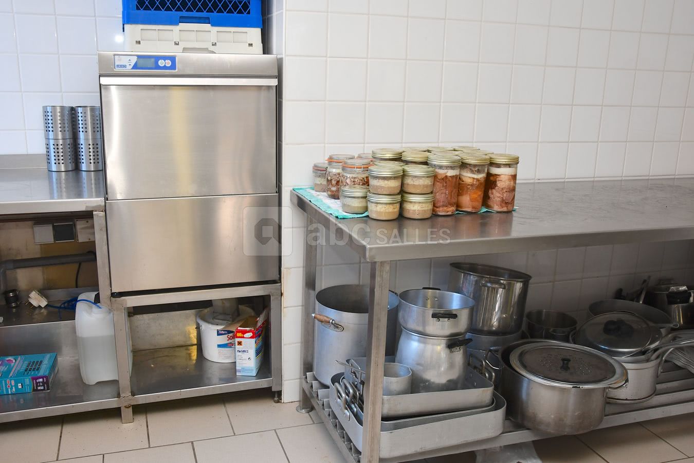 Cuisine vu du lave vaisselle professionnel avec tables de préparation et ces deux chambres froide