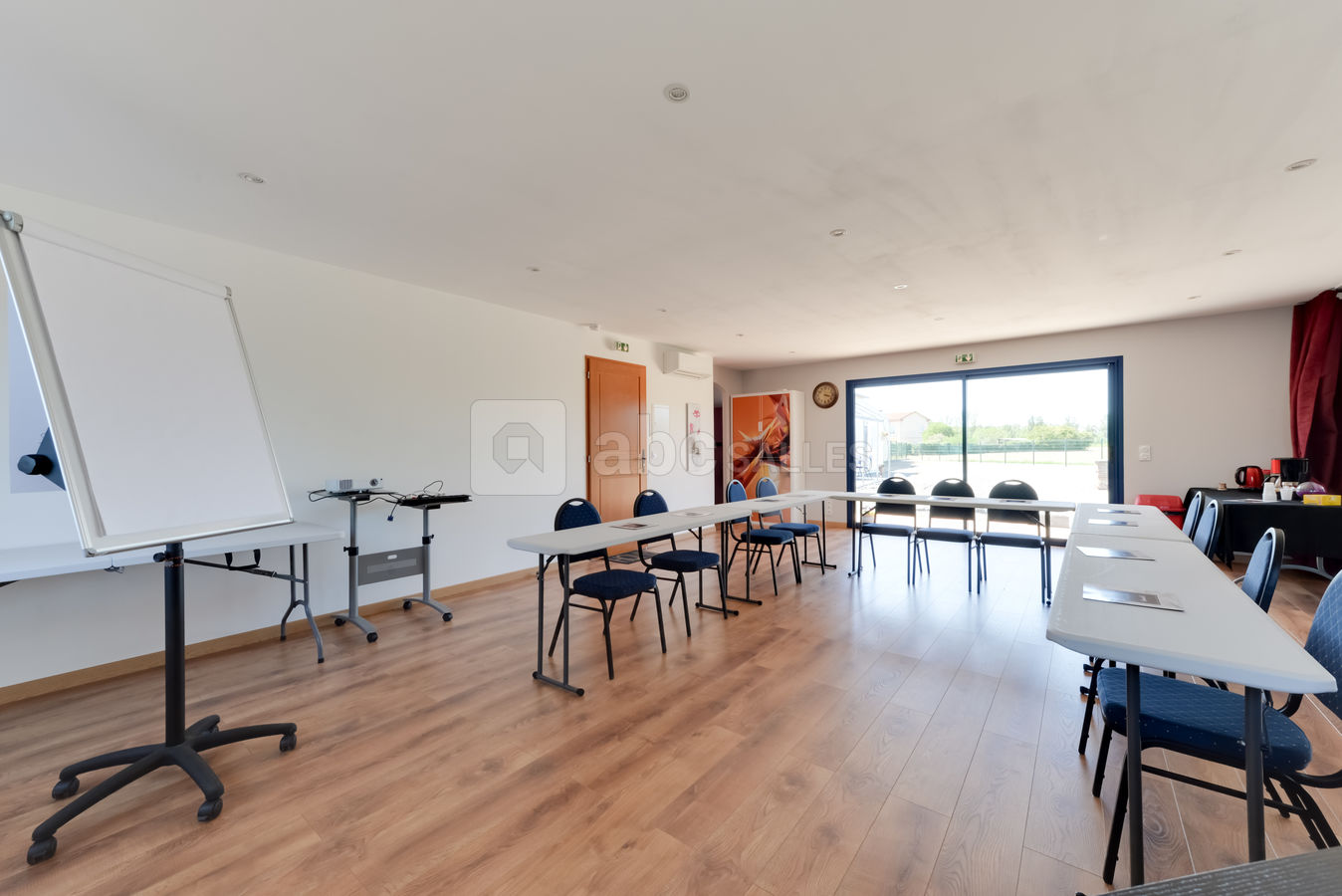 Salle lumineuse donnant sur des champs