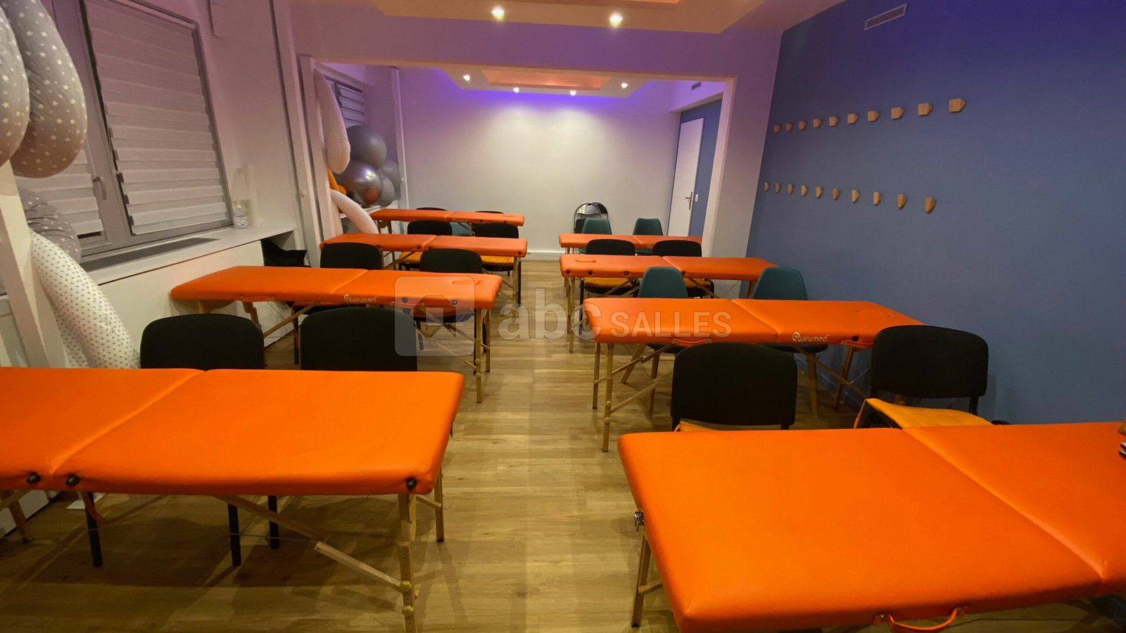 Salle de formation avec 8 tables de pratique ostéopathique et 32 chaises