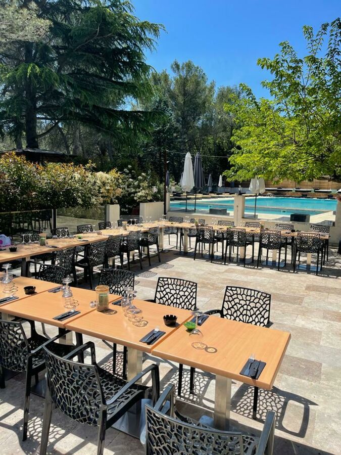 Une belle et grande terrasse d'été avec sa cuisine d'été et sa vue piscine