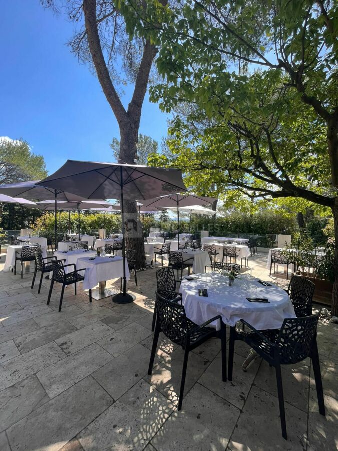 Une belle et grande terrasse d'été avec sa cuisine d'été et sa vue piscine